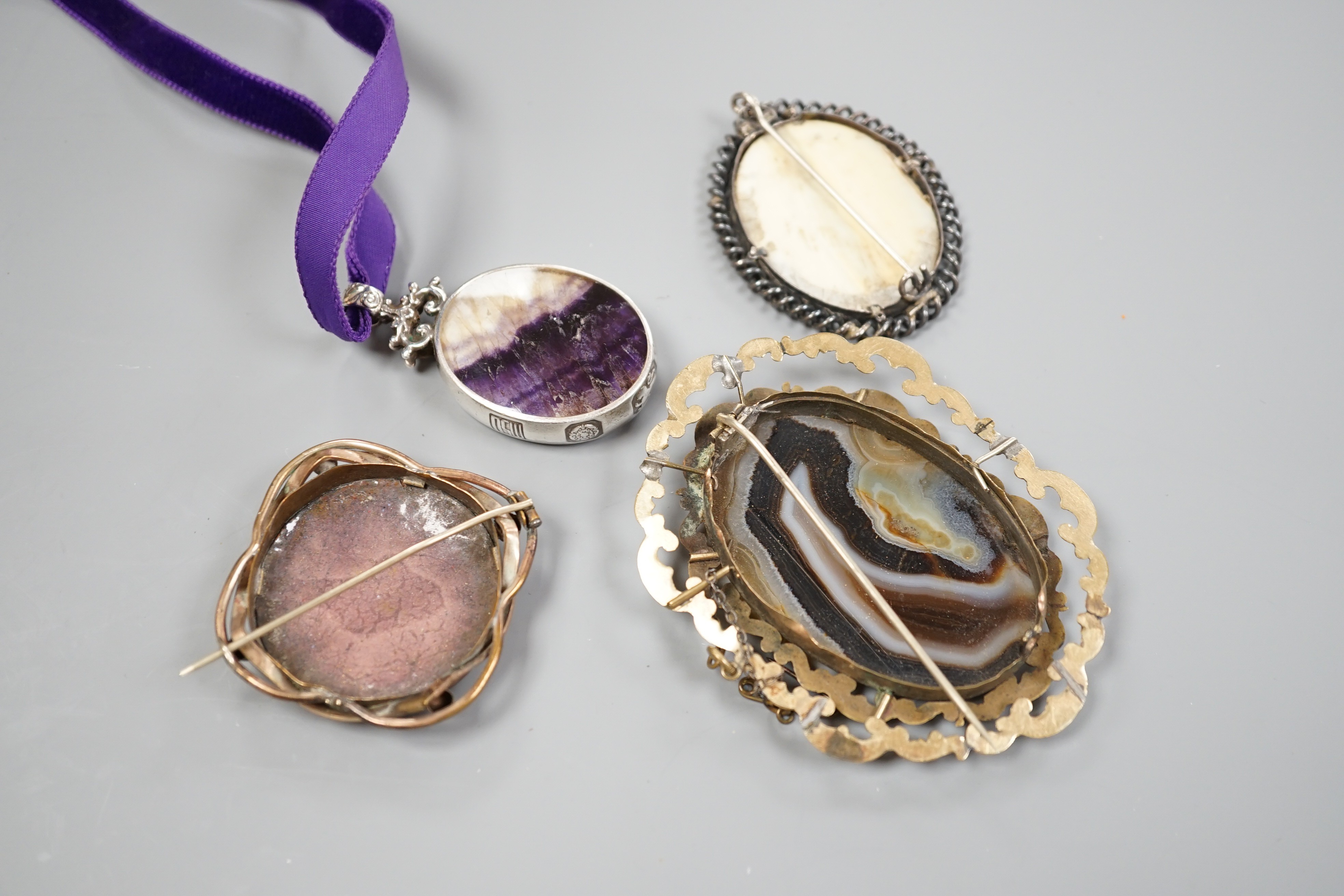 A modern silver mounted bluejohn oval pendant and three other brooches including banded agate.